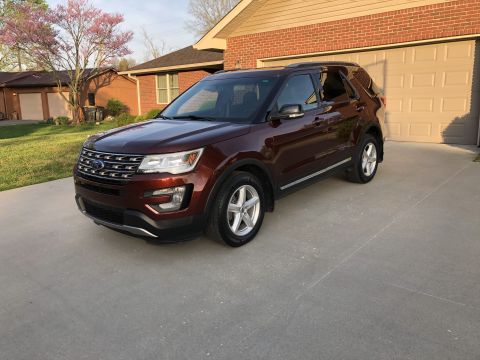2016 Ford Explorer - Maroon 2016 Ford Explorer parked on a concrete driveway next to a house.