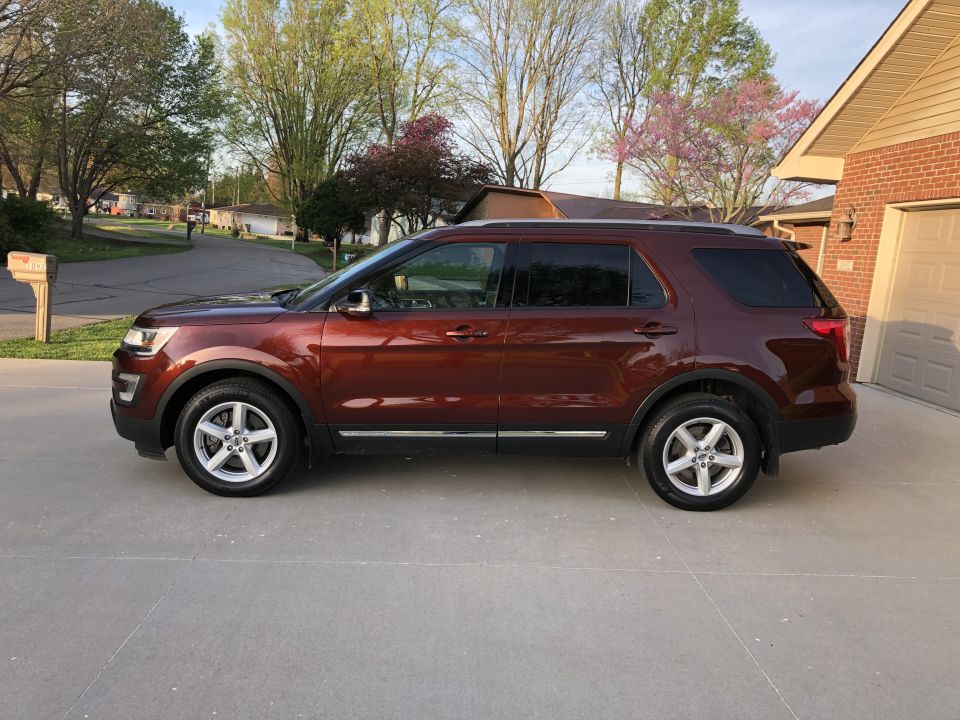 Side view of a red 2016 Ford Explorer parked in a driveway