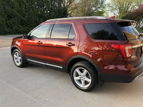 2016 Ford Explorer - The rear three-quarter view of a red 2016 Ford Explorer shows its detailed body lines and alloy wheels.