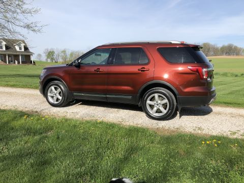 2016 Ford Explorer - This 2016 Ford Explorer is seen from a 3q-front angle, parked on a gravel driveway with a house in the background.