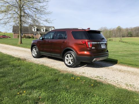 2016 Ford Explorer - Rear view of a brown 2016 Ford Explorer on a gravel driveway with a house in the background.