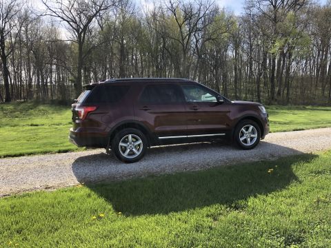 2016 Ford Explorer - This Ford Explorer is parked on a gravel driveway with a grassy area and trees in the background.