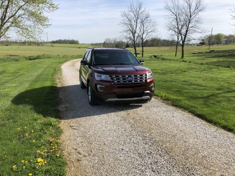 2016 Ford Explorer - 2016 Ford Explorer on a gravel driveway with green fields and trees in the background.