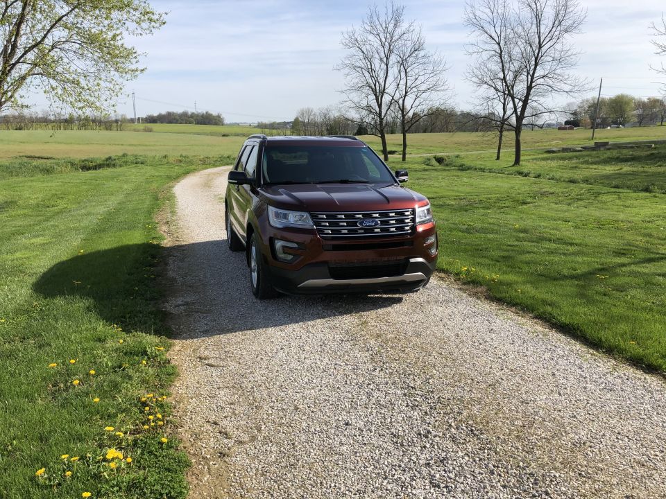 Maroon 2016 Ford Explorer parked on a gravel driveway in a rural setting