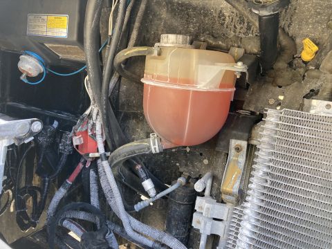 2015 Ford F-550 - Engine bay shows a coolant reservoir and part of the radiator.
