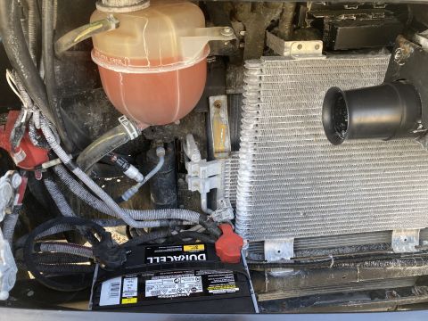 2015 Ford F-550 - Engine bay view showing a Duracell battery, coolant reservoir, and radiator assembly.