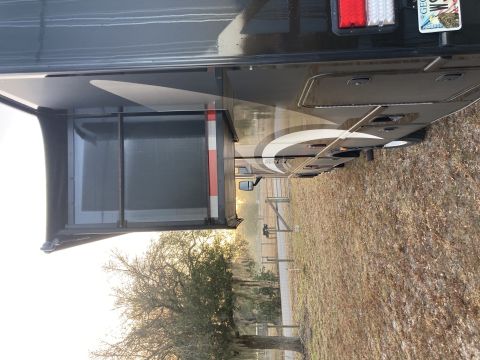 2015 Ford F-550 - Side view of a motorhome with its slide-out extended, parked in a grassy area.