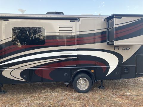 2015 Ford F-550 - This RV, labeled "FLAIR", is parked outdoors on a grassy area with stabilizers deployed.