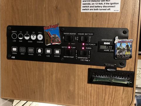 2015 Ford F-550 - RV monitor panel displays tank levels, battery status, and generator information, with attached souvenir pins.
