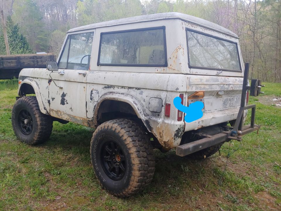 White 1977 Ford Bronco with off-road tires and a rear hitch