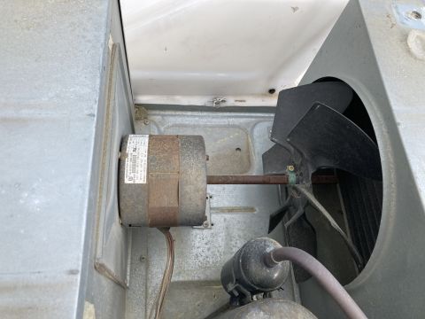 2015 Ford F-550 - Close-up view of an air conditioner motor and fan assembly, showing internal components and a label.