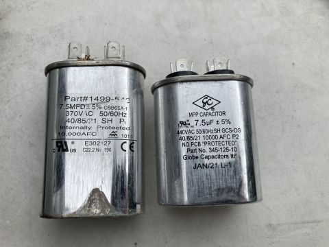 2015 Ford F-550 - Two cylindrical metal run capacitors rated 7.5 MFD with printed specifications rest side by side on a concrete surface.