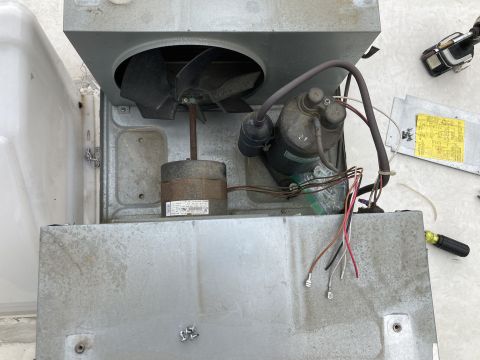 2015 Ford F-550 - Close-up of an air conditioner unit's internal components, including a fan and compressor, with wiring exposed.