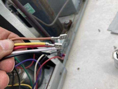 2015 Ford F-550 - A hand holds a bundle of wires with metal crimp connectors, ready for connection to an air conditioning unit.