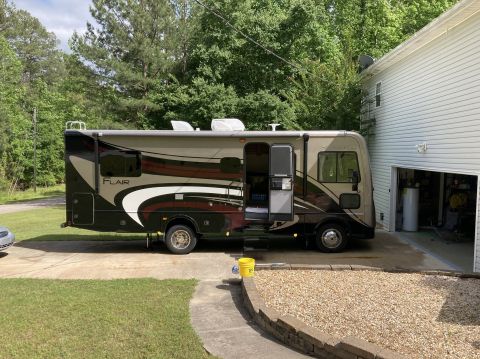 2015 Ford F-550 - A motorhome is parked on a driveway next to a residential building.