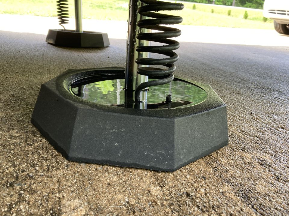 RV leveling jack base with coiled spring and water