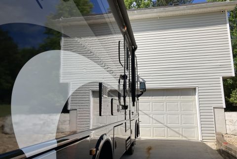 2015 Ford F-550 - A motorhome is parked in front of a residential garage on a sunny day.