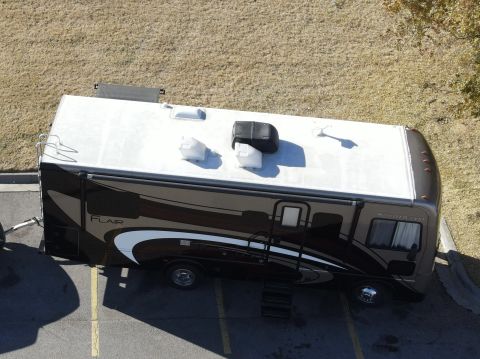 2015 Ford F-550 - Motorhome with 'FLAIR' graphics is parked in a lot.