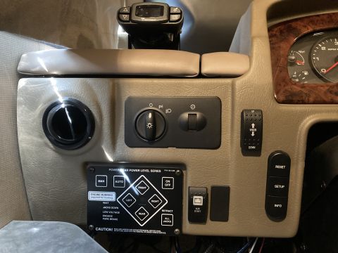 2015 Ford F-550 - Close-up of RV dashboard controls, including light switches and a leveling system panel.