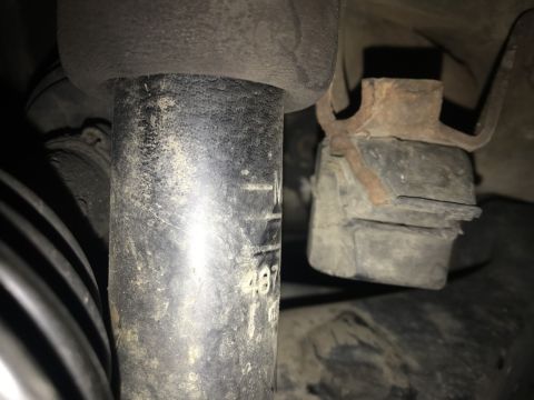 2000 Ford Explorer - A close-up view of a vehicle's suspension system, showing a shock absorber and mounting hardware.