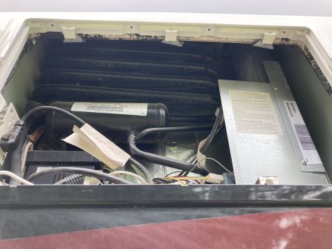 2015 Ford F-550 - Internal components of a Dometic DM2652LBFX refrigerator, including the compressor and cooling fins.