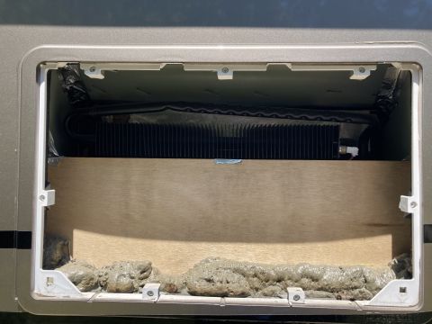 2015 Ford F-550 - The open compartment reveals cooling fins and unfinished wood, with a visible sealant at the base.