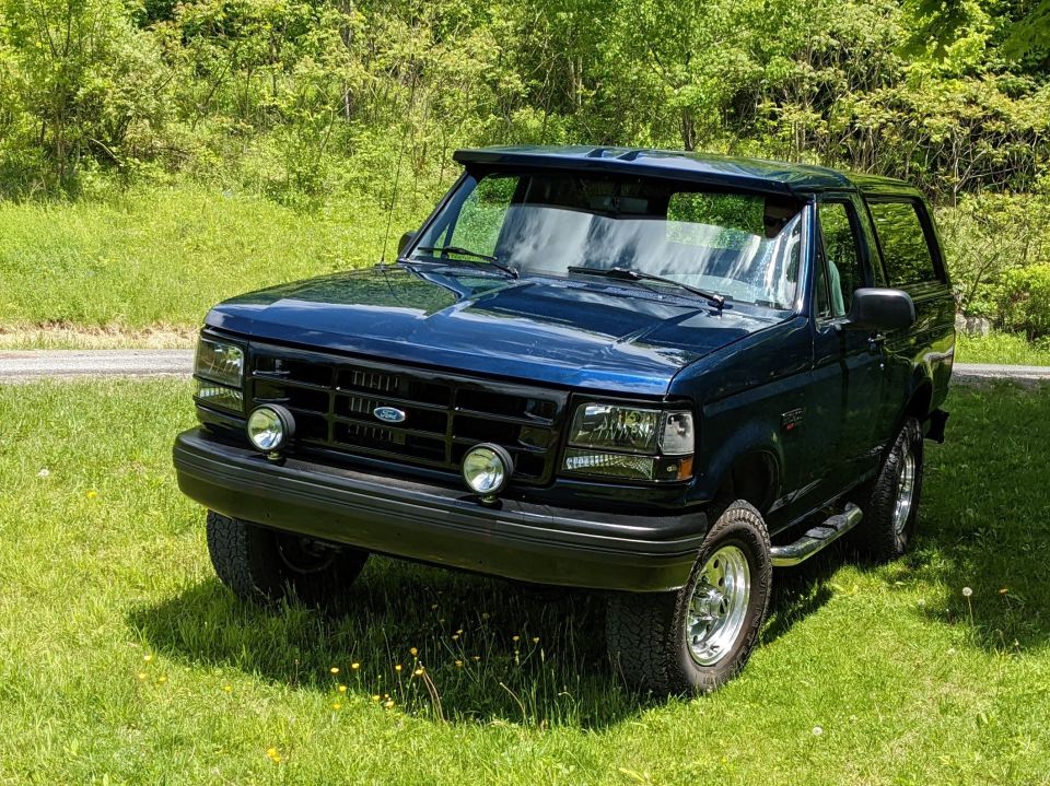 Dark blue 1996 Ford Bronco 3/4 front view on grassy knoll