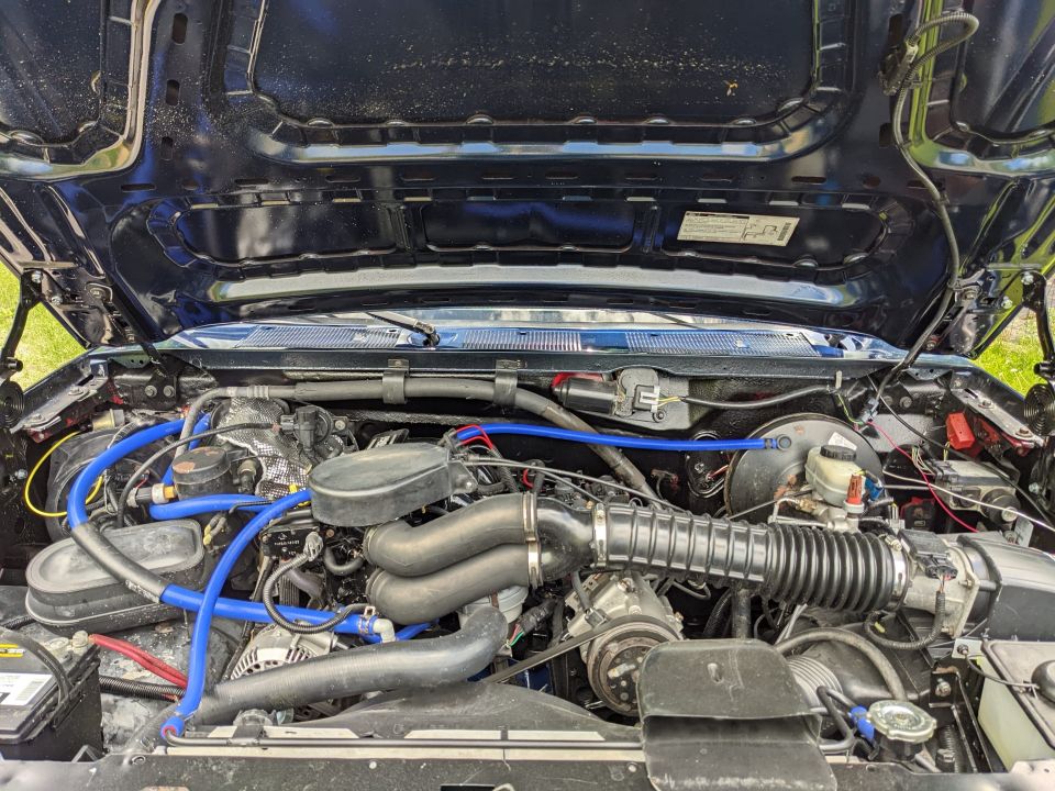 Engine bay with blue hoses and black hood open