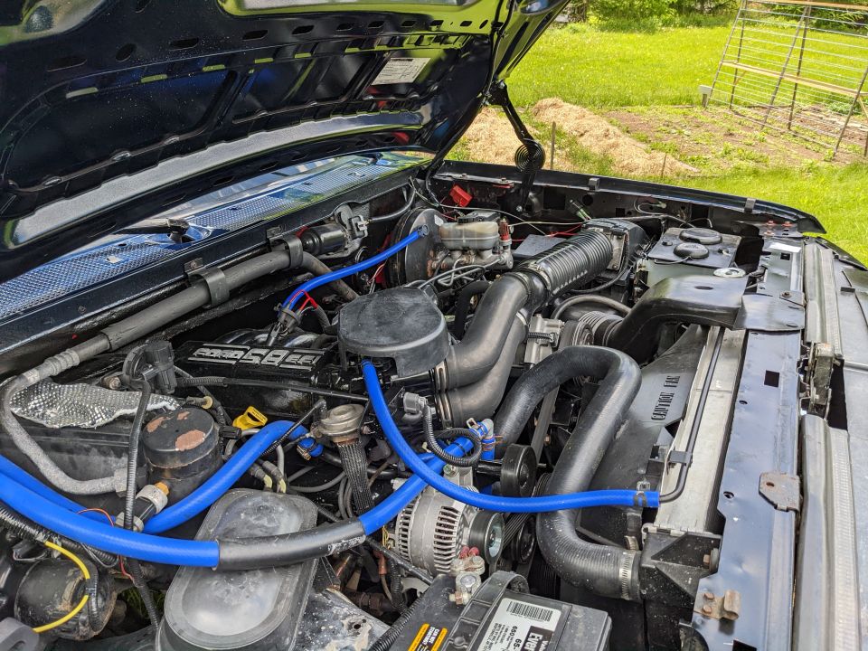 Engine bay with blue hoses and a black engine cover. Text on engine cover reads 'POWER STROKE'