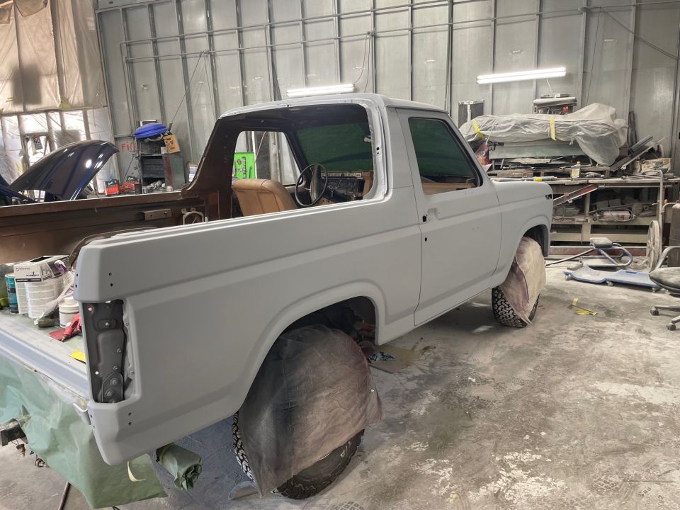 Ford Bronco in body shop, primer coat on, interior visible