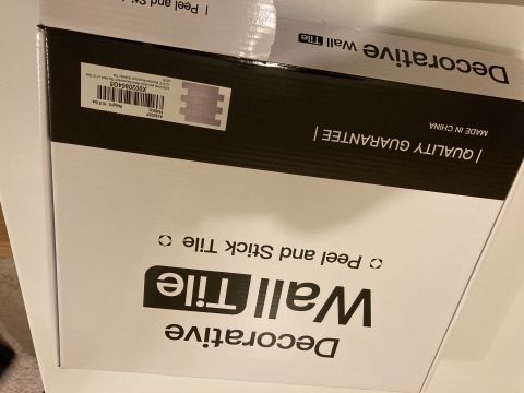 2015 Ford F-550 - A box labeled 'Decorative Wall Tile' and 'Peel and Stick Tile' is shown, with a quality guarantee and 'Made in China' visible.