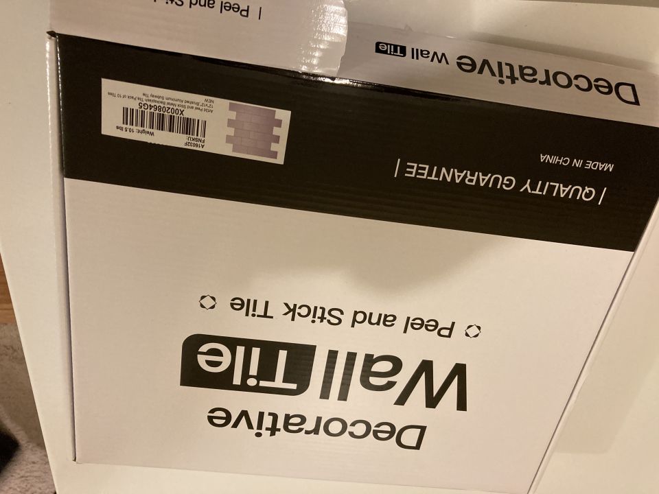 Box of peel and stick decorative wall tiles