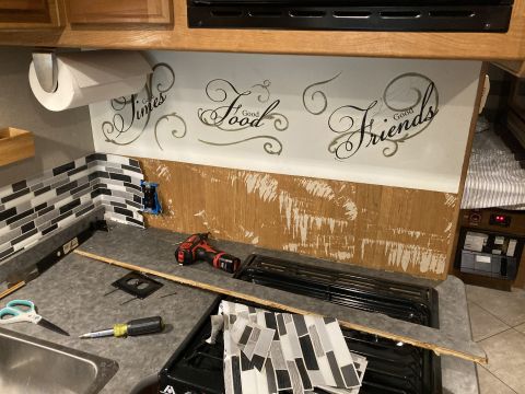 2015 Ford F-550 - Kitchen backsplash renovation with decorative text and tile, showing tools and materials on the counter.