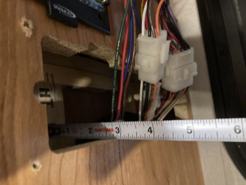 2015 Ford F-550 - A measurement tape is placed next to a bundle of wires and connectors, indicating a specific dimension within a panel.