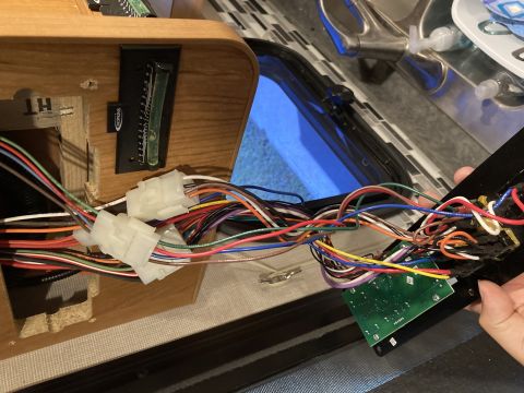 2015 Ford F-550 - A close-up view of a complex wiring harness connected to a circuit board and a gauge on a wooden panel.