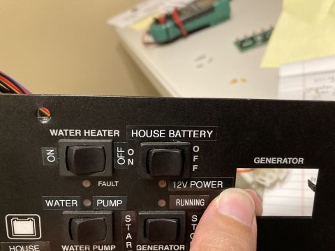2015 Ford F-550 - Close-up of a control panel labels for water heater, house battery, and generator functions.