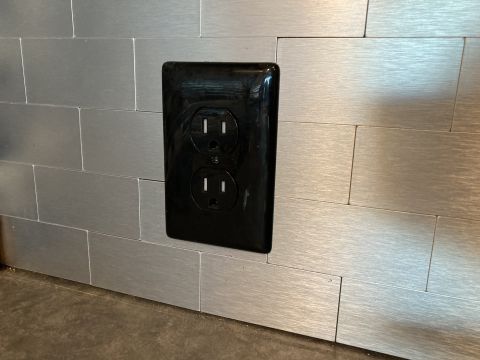 2015 Ford F-550 - Electrical outlet mounted on a brushed metal backsplash panel.