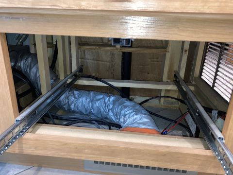 2015 Ford F-550 - Visible ductwork and wiring are seen behind wooden cabinets, suggesting an internal system or installation.