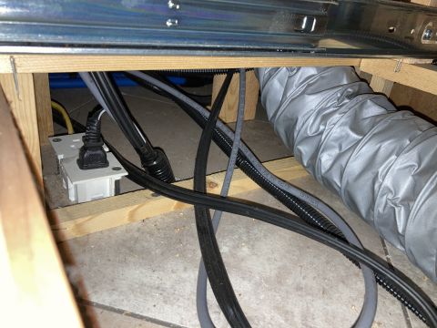 2015 Ford F-550 - Close-up view of an electrical outlet and various wires and a flexible duct, likely installed behind cabinets.