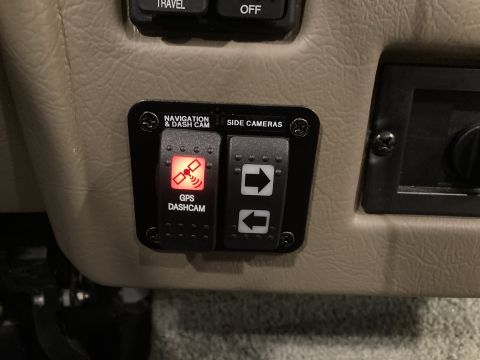 2015 Ford F-550 - Close-up of dashboard switches labeled 'Navigation & Dash Cam' and 'Side Cameras', with the 'GPS Dashcam' button illuminated.