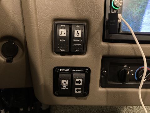 2015 Ford F-550 - Interior view of dashboard switches and controls, including power, radio, generator, and camera functions.