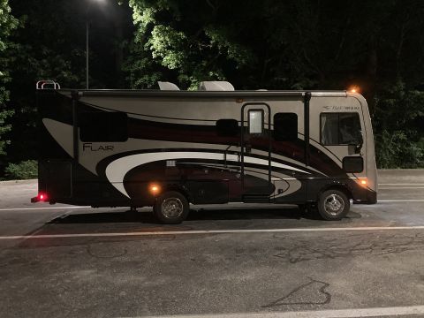 2015 Ford F-550 - This RV motorhome has a distinctive graphic design on its side and is parked under a street light at night.