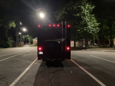 2015 Ford F-550 - RV parked at night with lights illuminated.