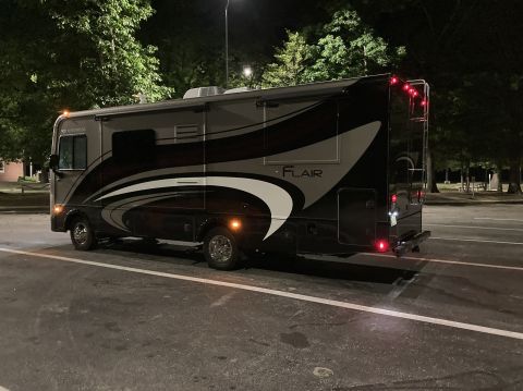 2015 Ford F-550 - This RV motorhome is parked at night, showing its side profile with distinctive graphics.