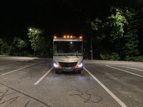 2015 Ford F-550 - Motorhome parked in a lot at night, front view. 'FLAR' is visible on the top.