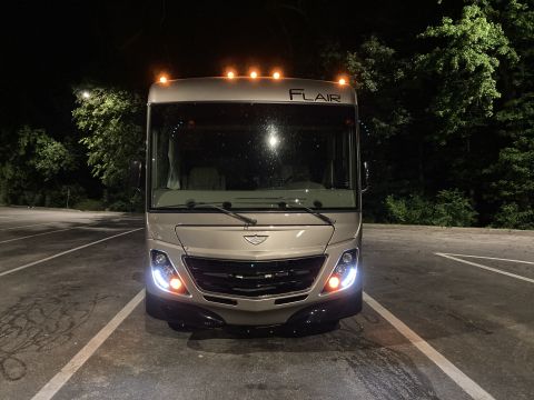2015 Ford F-550 - This RV motorhome is parked in a lot at night, with its headlights and marker lights illuminated.