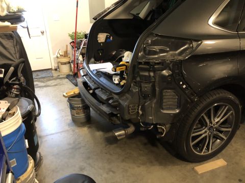 2019 Ford Everest - SUV's rear bumper removed, exposing internal structure and exhaust system during a repair or modification.