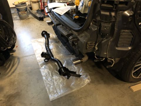 2019 Ford Everest - The rear of a vehicle is disassembled, showing the bumper removed and a tow hitch receiver nearby.