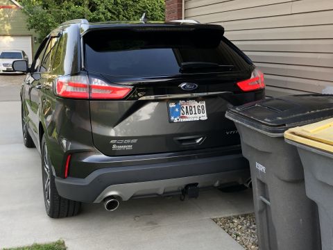 2019 Ford Everest - Rear view of a dark SUV, showing the tow receiver and license plate SAB168. Another vehicle is visible in the background.