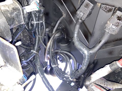 2015 Ford F-550 - Close-up view of complex engine wiring and various black components, likely part of an air horn system.
